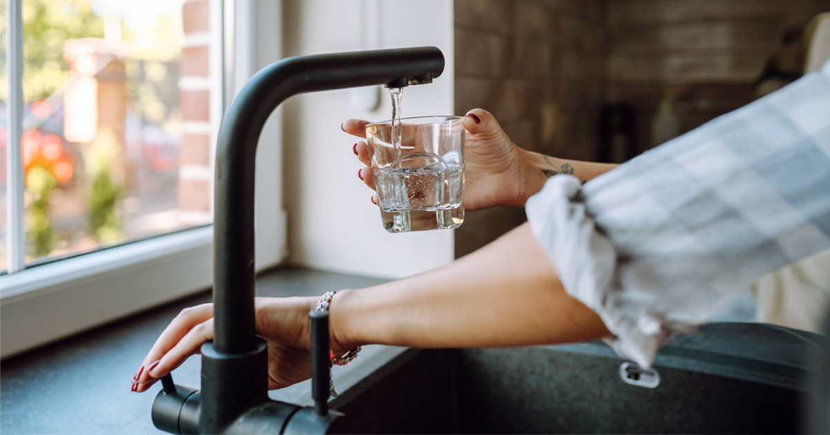 Vaso de agua del grifo con aspecto turbio por cloro en Barcelona en verano